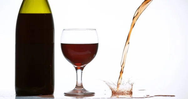 Rode Wijn Die Glas Wordt Gegoten Tegen Witte Achtergrond — Stockfoto