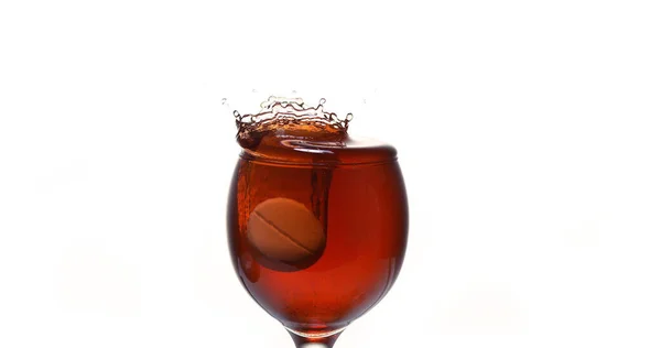 Tablet Faller Ner Ett Glas Rött Vin Mot Vit Bakgrund — Stockfoto