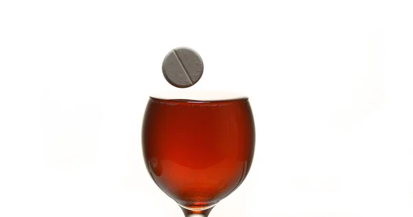 Δισκίο Πέφτει Ένα Ποτήρι Κόκκινο Κρασί Ενάντια Στο Λευκό Φόντο — Φωτογραφία Αρχείου