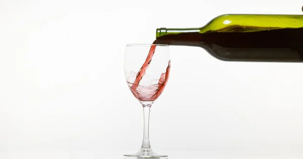 Vinho Tinto Sendo Derramado Vidro Contra Fundo Branco — Fotografia de Stock