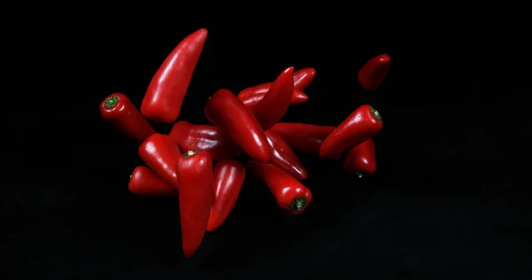 赤い甘いペッパー カプシウム年 黒い背景に落ちる野菜 — ストック写真