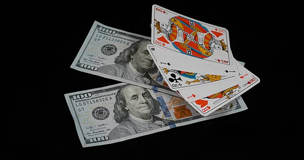 在黑色背景下 扑克掉在美元钞票上 — 图库照片