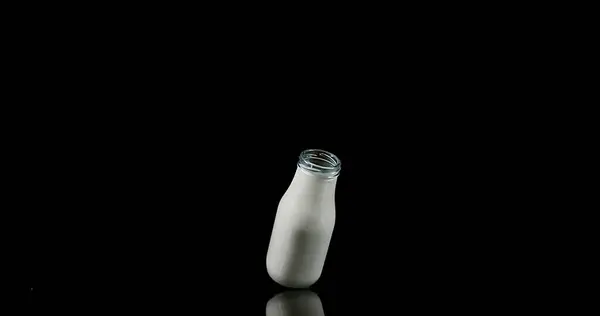 Fles Van Melk Vallen Ploegen Tegen Zwarte Achtergrond — Stockfoto