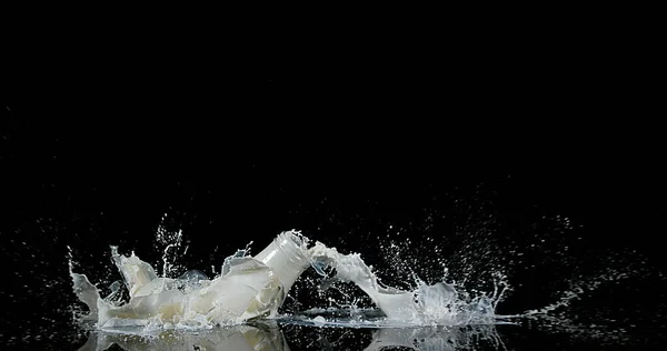 Milchflasche Fällt Und Explodiert Vor Schwarzem Hintergrund — Stockfoto