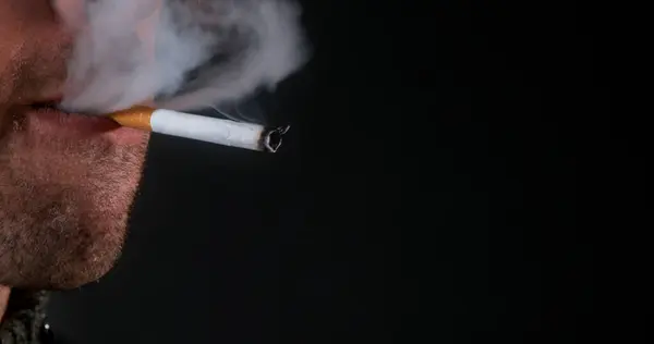 Человек Курящий Сигарету Черном Фоне — стоковое фото