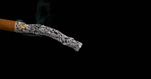 在黑色背景下消费的香烟 — 图库照片