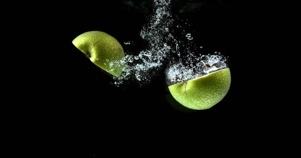 Granny Smith Apples, malus domestica, Fruits entering Water against Black Background