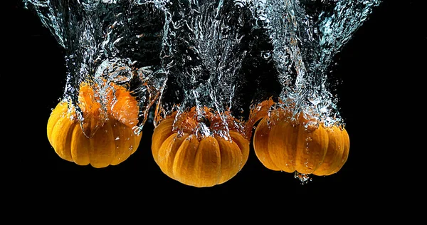 Zwergkürbis Cucurbita Pepo Ins Wasser Fallende Früchte Vor Schwarzem Hintergrund — Stockfoto