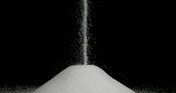 Açúcar Branco Caindo Contra Fundo Preto — Fotografia de Stock