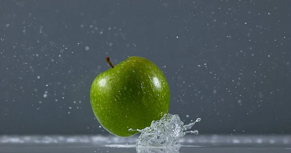 Granny Smith Apple, malus domestica, Fruit falling on Water against Black Background