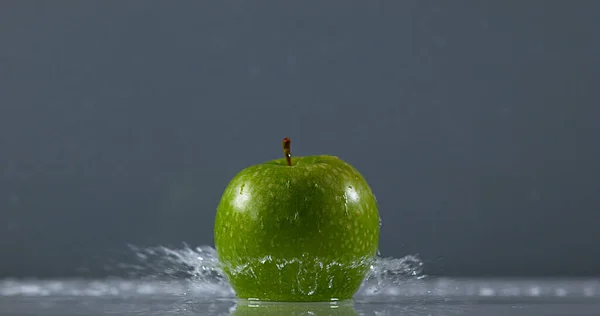 Granny Smith Apple, malus domestica, Fruit falling on Water against Black Background