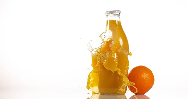Fles Oranje Exploderende Tegen Witte Achtergrond — Stockfoto