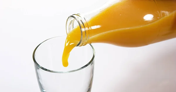 Jus Jeruk Dituangkan Dalam Kaca Melawan Latar Belakang Putih — Stok Foto