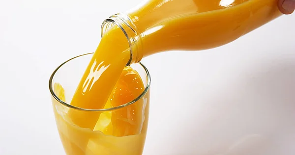 Orange Juice Som Hälls Glas Mot Vit Bakgrund — Stockfoto