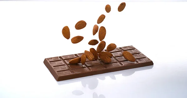 ミルクチョコレートタブレットに落ちるアーモンド — ストック写真