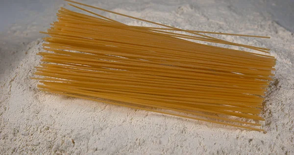 小麦粉に落ちるスパゲッティパスタ — ストック写真