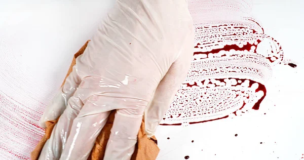 Mão Enluvada Que Limpa Sangue Contra Fundo Branco — Fotografia de Stock