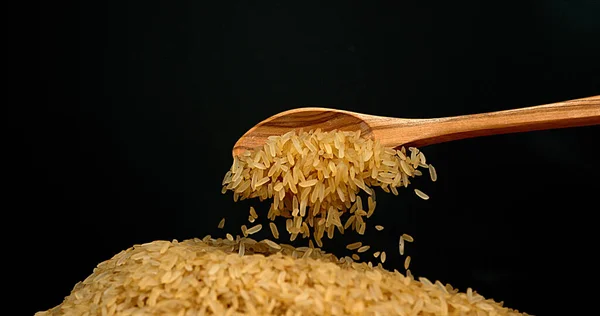 Ryż Spada Drewnianej Łyżce Czarnym Tle — Zdjęcie stockowe
