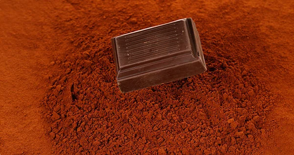 Black Chocolate Tablet falling on Black Chocolate Powder