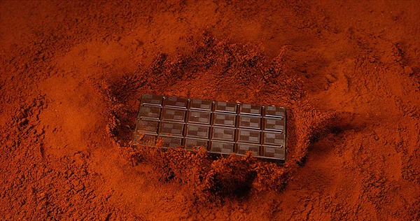 黒チョコレートパウダーに落ちるブラックチョコレートタブレット — ストック写真