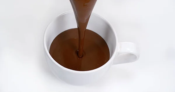 Σοκολάτα Pouring Ένα Μπολ Κατά Λευκό Φόντο — Φωτογραφία Αρχείου