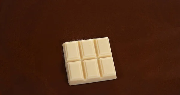 White Chocolate Tablet falling into Milk Chocolate