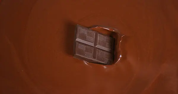 Black Chocolate tablet falling into Milk Chocolate
