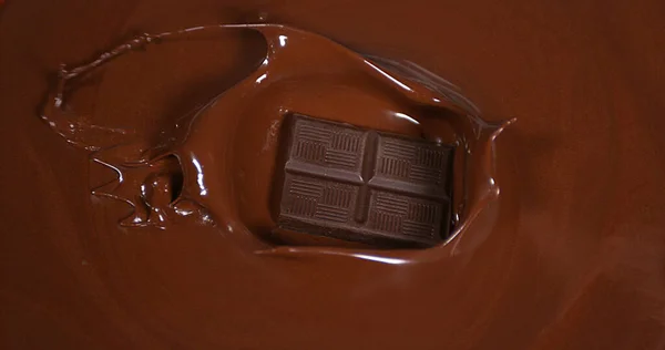 Black Chocolate tablet falling into Milk Chocolate