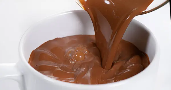 Chocolate Vertiendo Tazón Contra Fondo Blanco — Foto de Stock