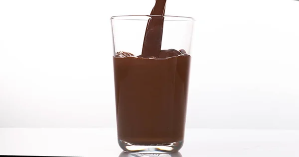 Chocolade Gieten Een Glas Tegen Witte Achtergrond — Stockfoto