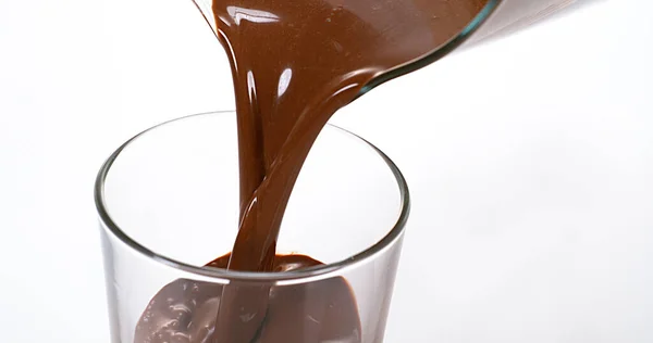 Cokelat Menuang Dalam Kaca Melawan Latar Belakang Putih — Stok Foto