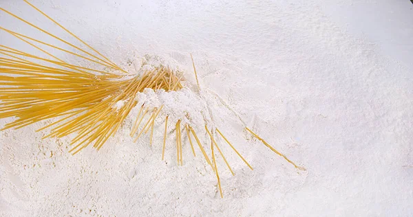 白い背景に対して小麦粉に落ちるパスタ — ストック写真