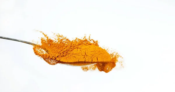 姜黄粉落在勺子上 印地安香料白底 — 图库照片