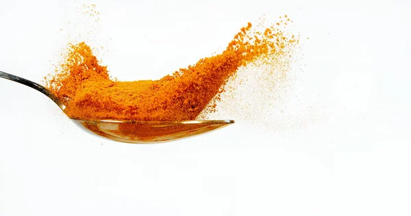 姜黄粉落在勺子上 印地安香料白底 — 图库照片