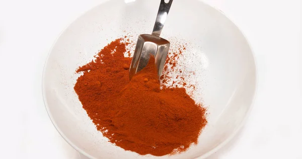 红辣椒 粉末在白色背景下掉进碗里 — 图库照片