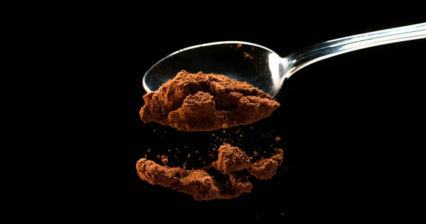 ナツメグ ミロネオの香り ブラックバックグラウンドに対するスプーンから落ちる粉 — ストック写真