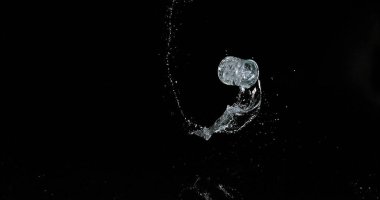 Bir bardak Su Zıplıyor ve Siyah Arkaplanda Sıçrıyor