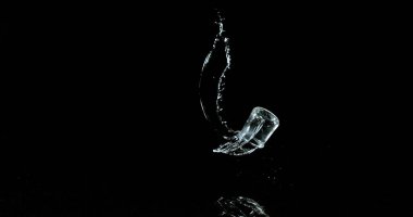 Bir bardak Su Zıplıyor ve Siyah Arkaplanda Sıçrıyor