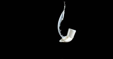 Bir bardak Süt Zıplıyor ve Siyah Arkaplanda Sıçrıyor