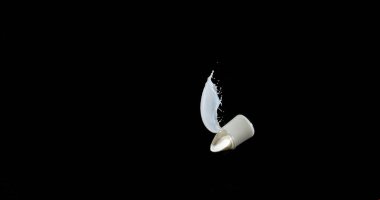 Bir bardak Süt Zıplıyor ve Siyah Arkaplanda Sıçrıyor