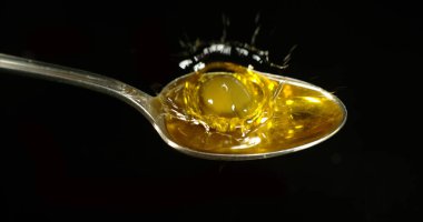 Yeşil zeytin, Olea avrupa, Siyah Arkaplan 'a karşı kaşıkta düşüş