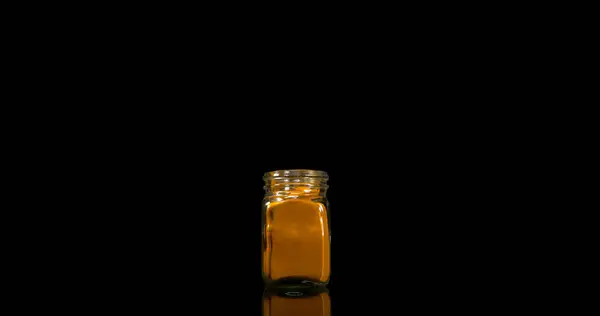 ウコン クルクマガム 黒い背景に落ちる小さな瓶に粉末 インドのスパイス — ストック写真