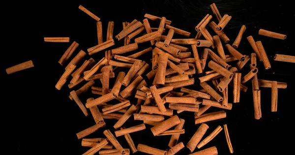 Palitos Canela Cinnamomum Zeylanicum Especias Que Caen Sobre Fondo Negro — Foto de Stock