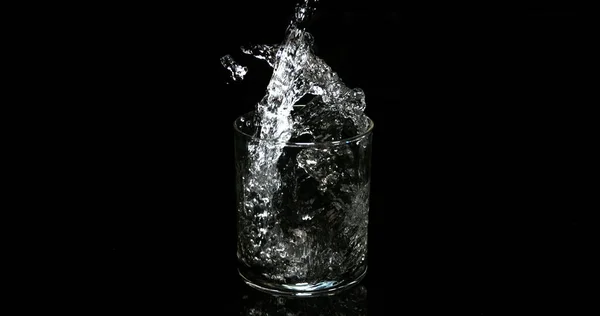 Agua Que Vierte Vidrio Contra Fondo Negro — Foto de Stock