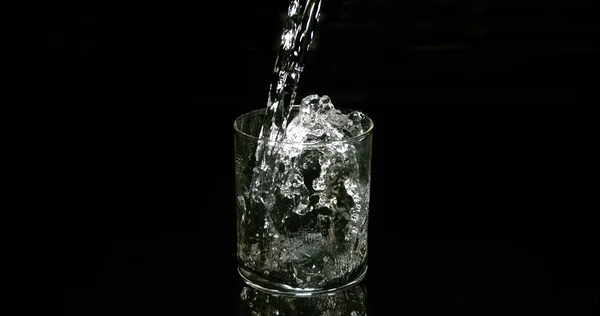 Water Dat Tegen Zwarte Achtergrond Glas Wordt Gegoten — Stockfoto