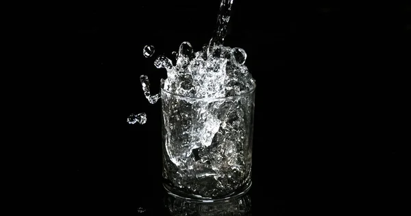 Agua Que Vierte Vidrio Contra Fondo Negro —  Fotos de Stock