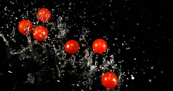 樱桃番茄 番茄红花 水果在黑色背景下落水 — 图库照片