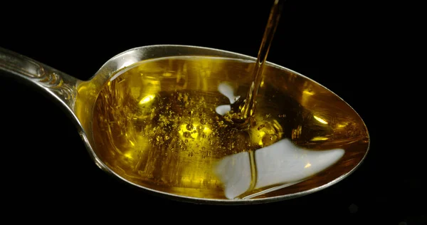 Olive Oil Jatuh Dalam Sendok Melawan Black Background — Stok Foto