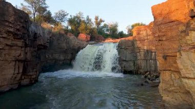 Nefes kesen bir şelale canlı doğanın ve etrafını saran engebeli kayalık arazinin arasında zarifçe çağlıyor.