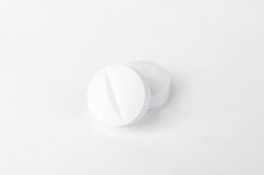 Birkaç beyaz parasetamol tabletinin yakın plan çekimi, sade beyaz arka planda izole edilmiş, sağlık ve tıbbı temsil ediyor. Yüksek kalite fotoğraf